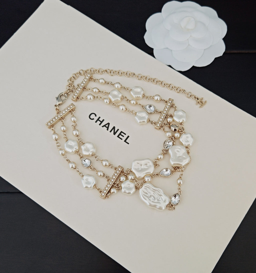 Chanel accessories: pearl and crystal charm necklace with CHANEL logo tag