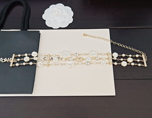 Chanel accessories: layered gold-tone chains with pearl beads and cross charms