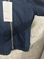 Dark navy zip-up hoodie front pocket area with gold zipper and hood seam