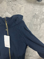 Dark navy zip-up hoodie sleeve and side seam detail with gold zipper trim