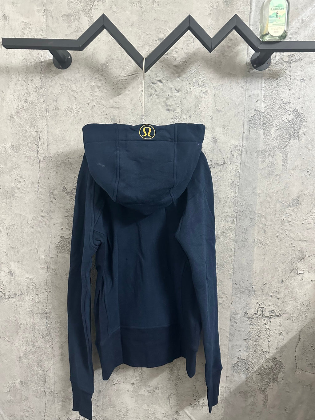 Dark navy zip-up hoodie with hood and small embroidered logo on the back
