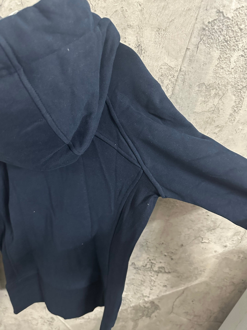 Dark navy zip-up hoodie close-up of hood and shoulder seam with zipper edge