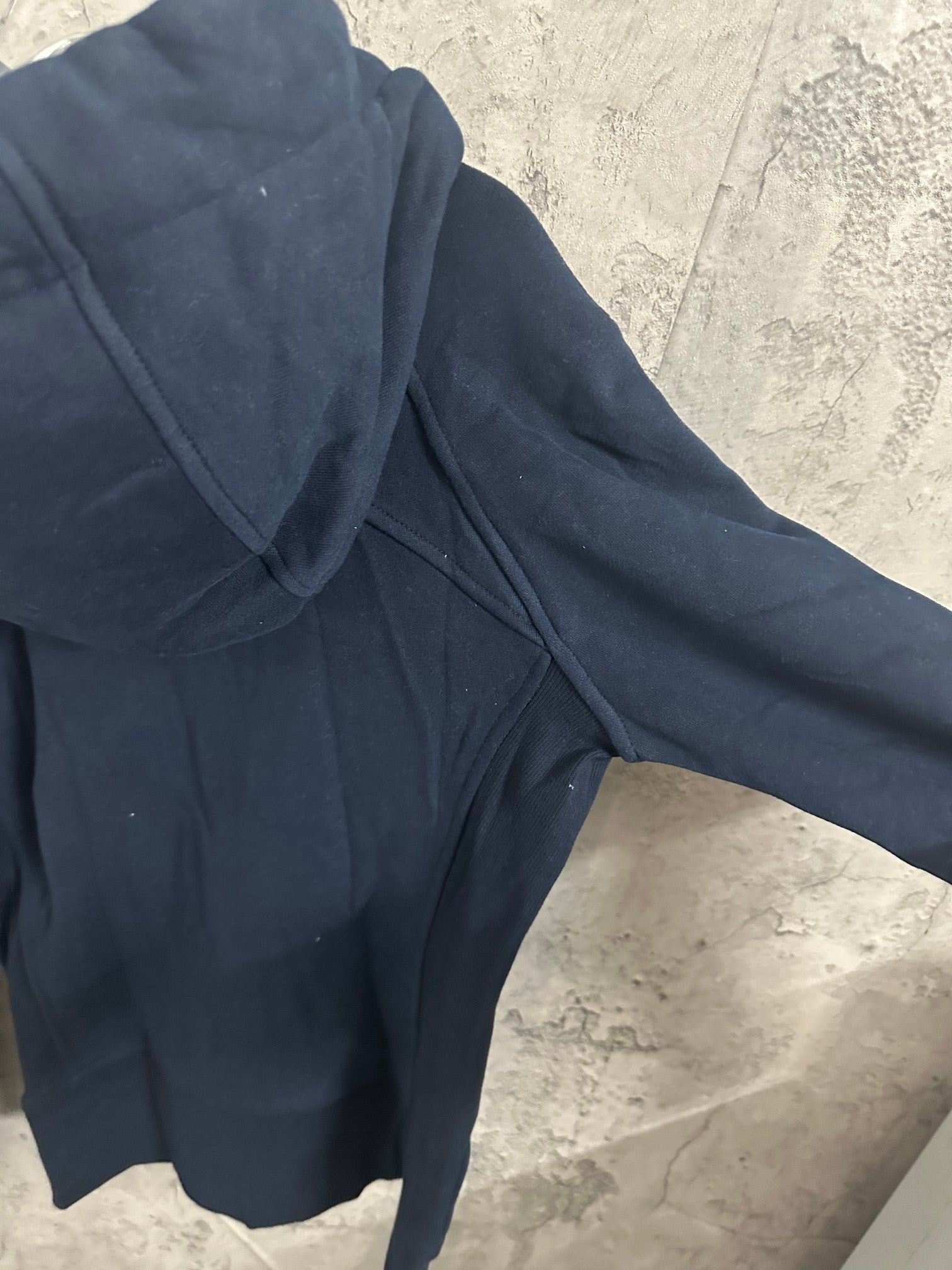 Dark navy zip-up hoodie close-up of hood and shoulder seam with zipper edge
