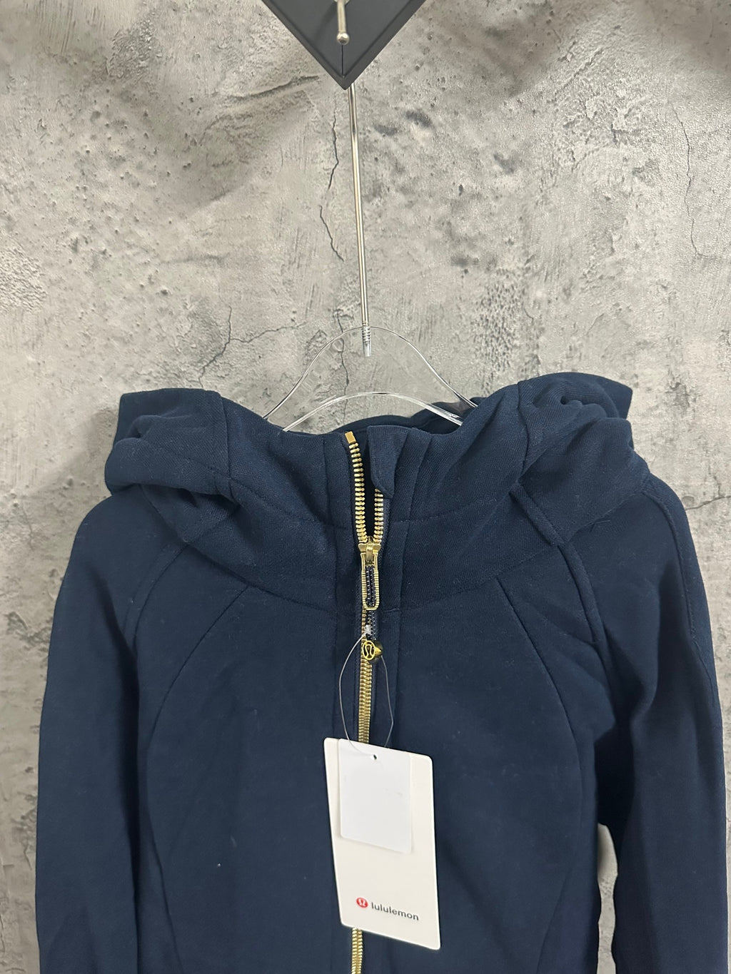 Dark navy zip-up hoodie with gold-toned zipper and adjustable drawstring hood