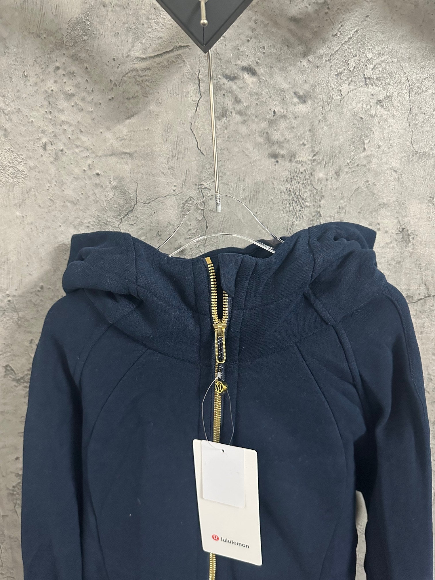 Dark navy zip-up hoodie with gold-toned zipper and adjustable drawstring hood