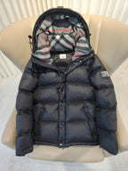 Puffer jacket close-up front, plaid hood lining, dark quilted body and zip closure