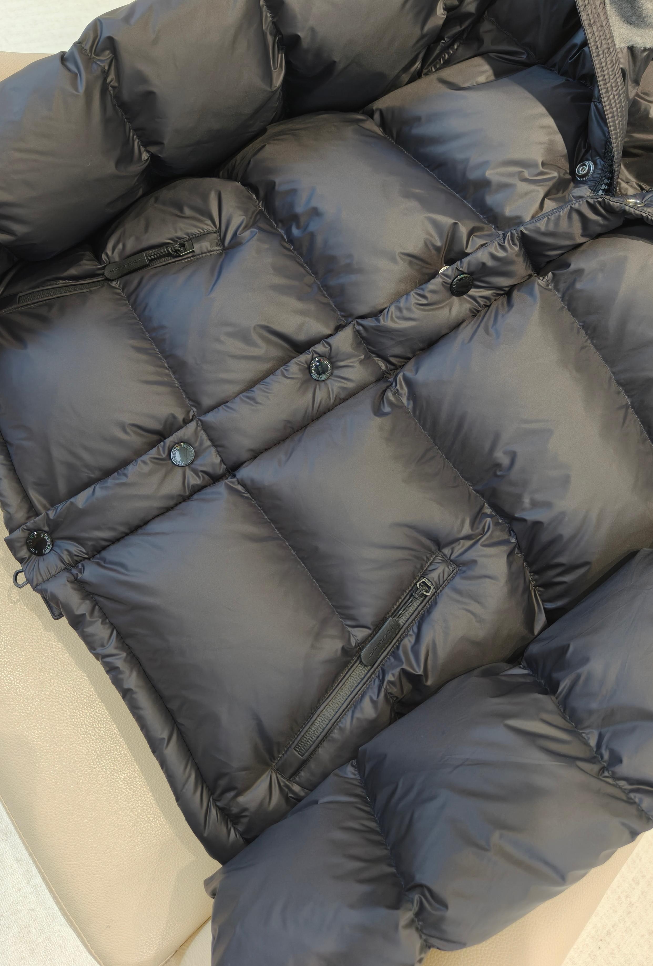 Quilted puffer jacket fabric detail with padded baffles, dark blue tone and buttons