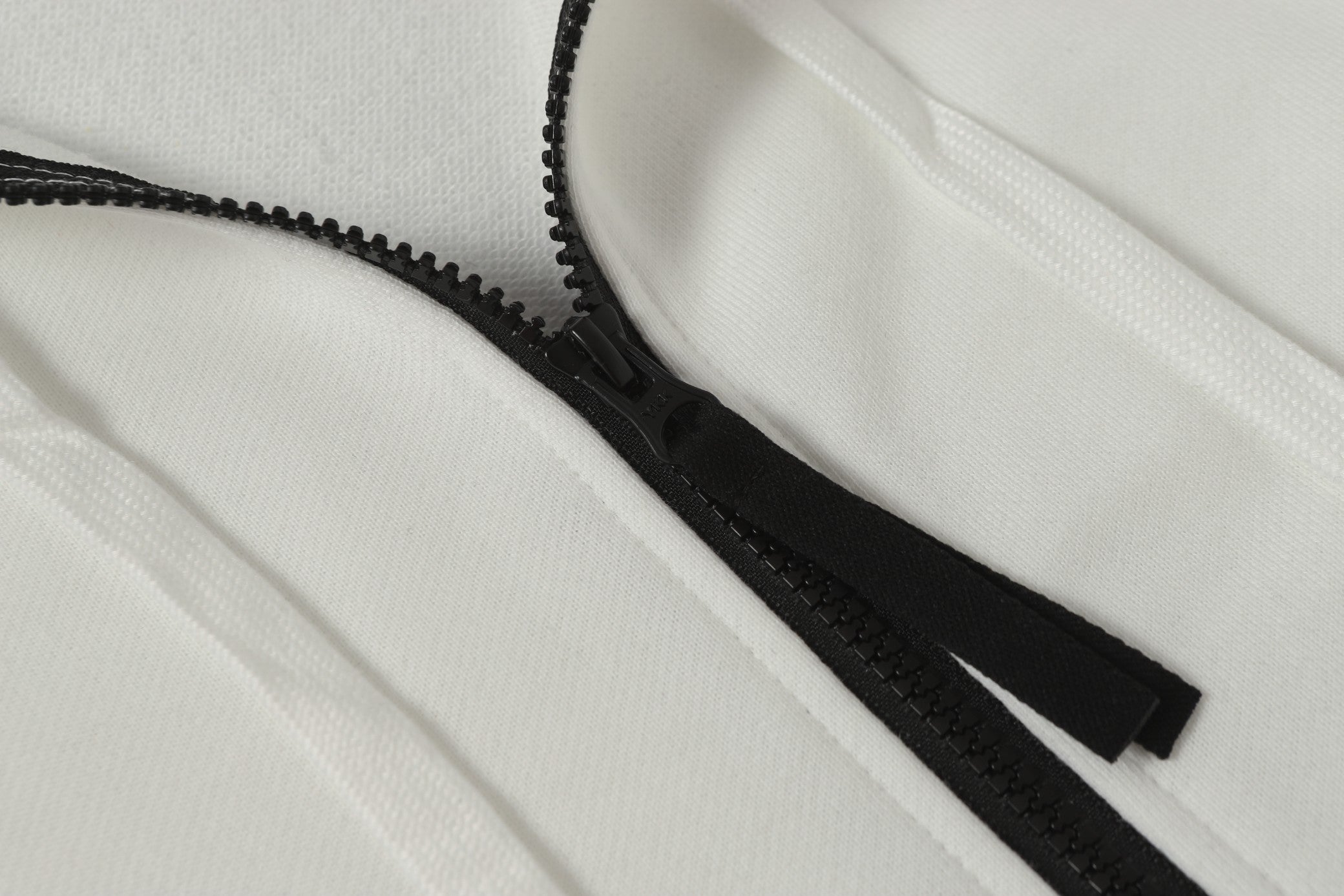 White hooded jacket with black zipper and exposed zipper track detail
