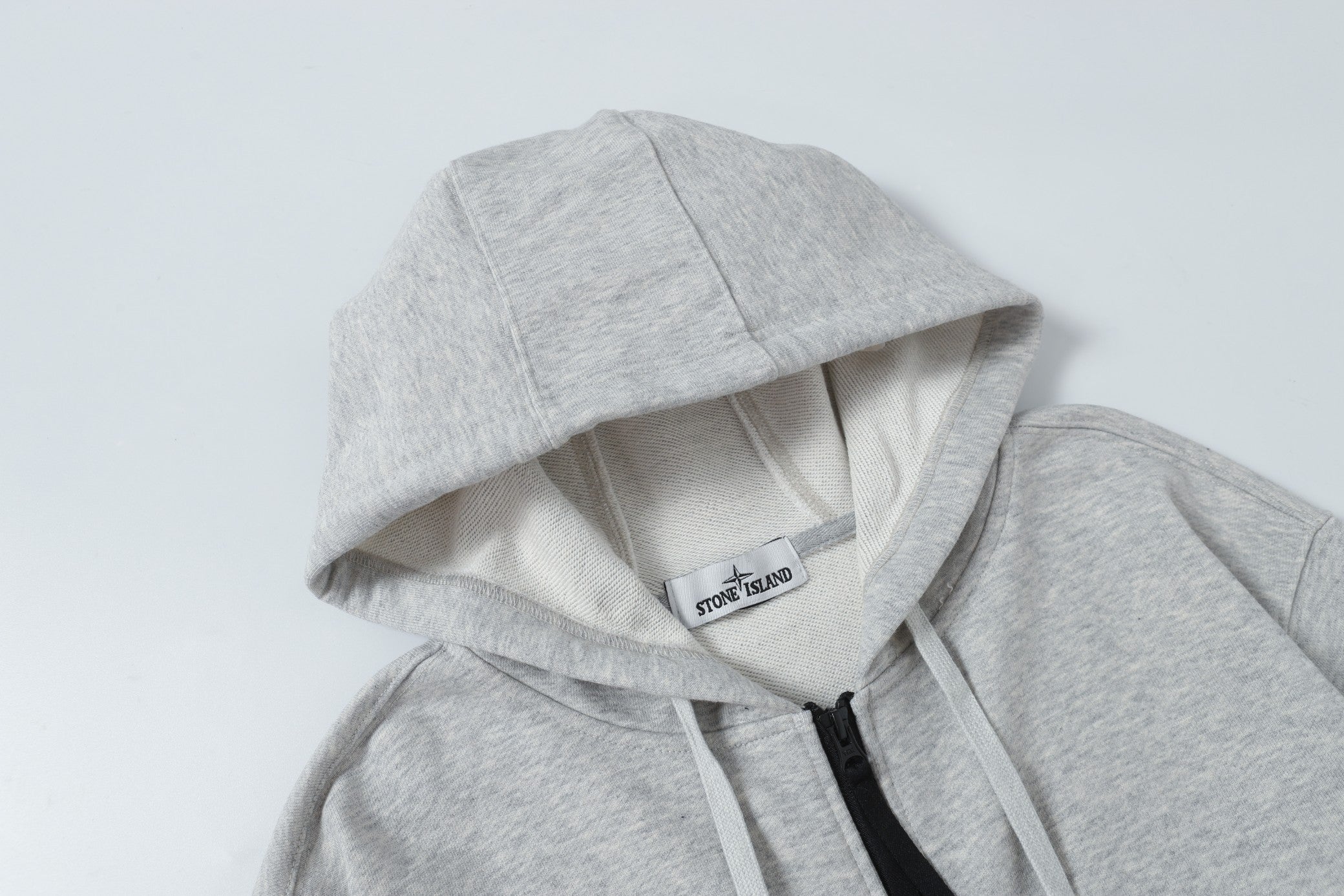 Light gray zip hoodie with hood lining and black zipper trim at front