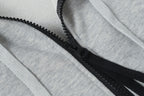 Black zipper detail on light gray hoodie placket with stitched edges