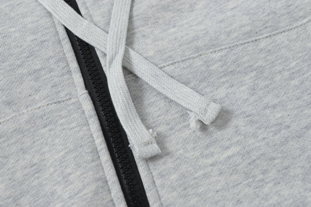 Light gray hoodie drawstring through hood with black zipper placket