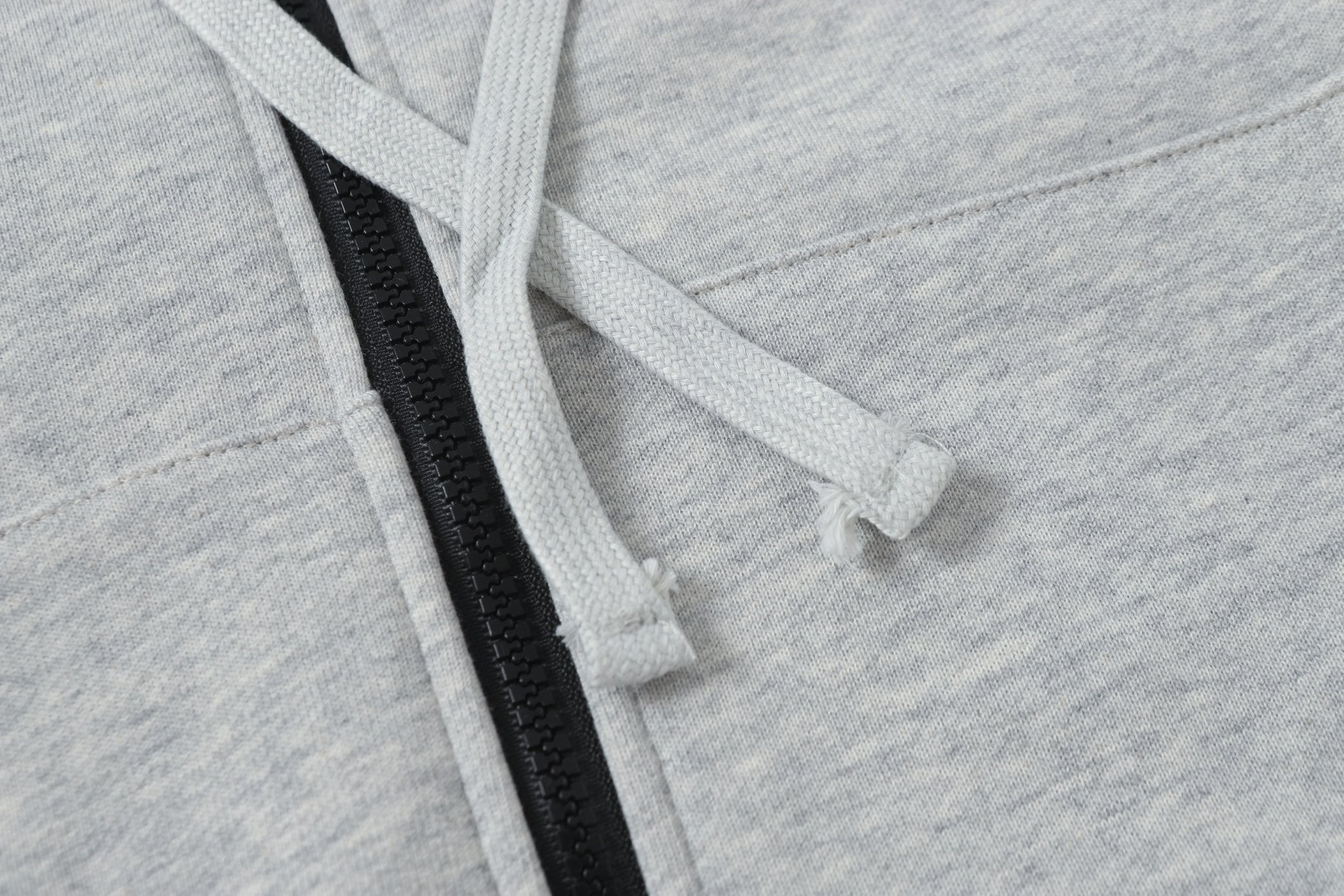 Light gray hoodie drawstring through hood with black zipper placket