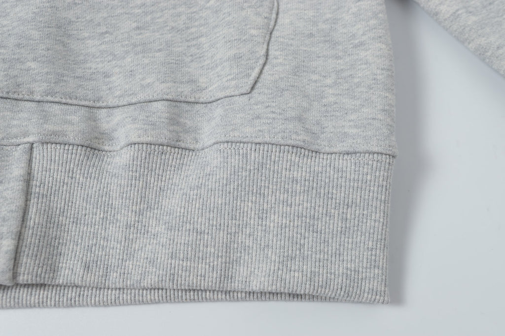 Light gray hoodie hem with ribbed knit cuff and stitched lower edge
