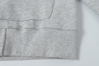 Light gray hoodie hem with ribbed knit cuff and stitched lower edge