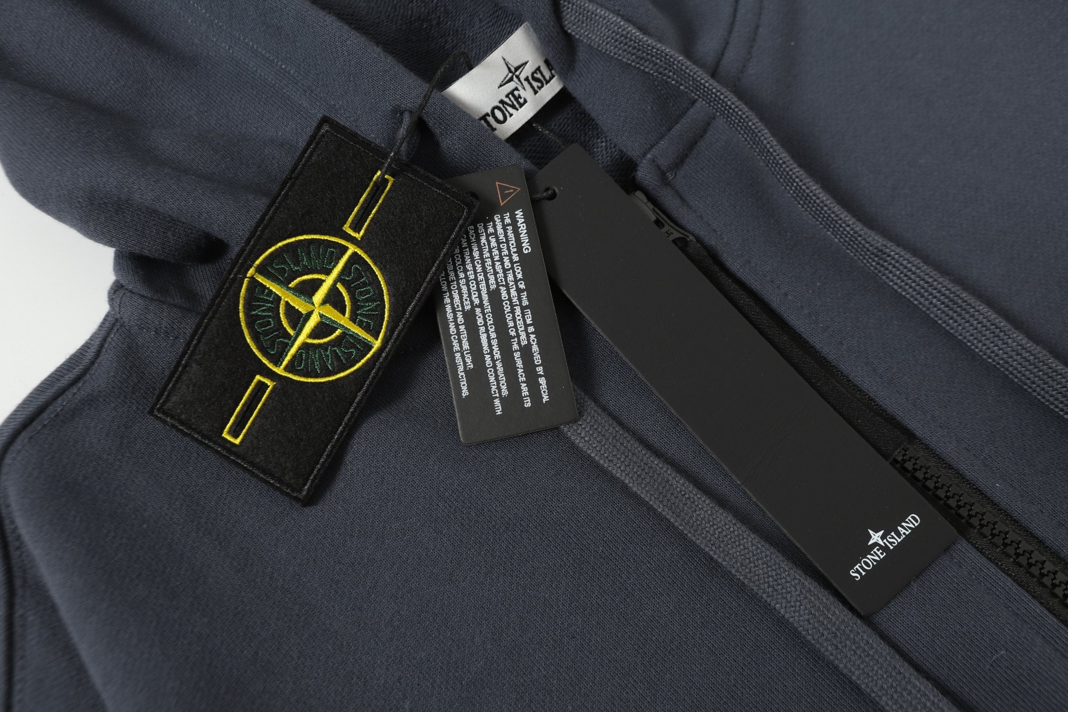 Stone Island patch on dark navy sleeve, with zipper and logo tags