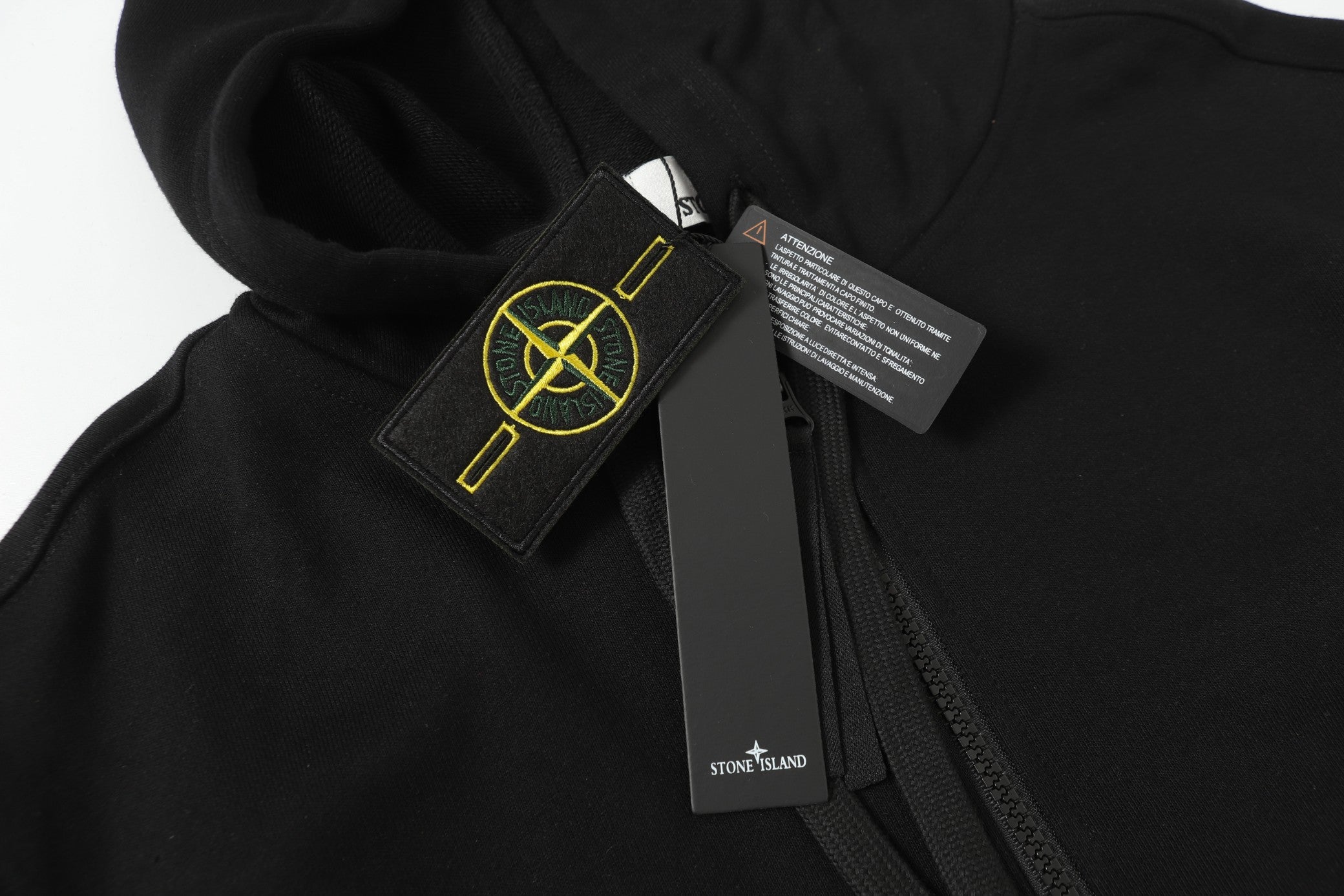Black hooded zip jacket close-up of hood patch and care label