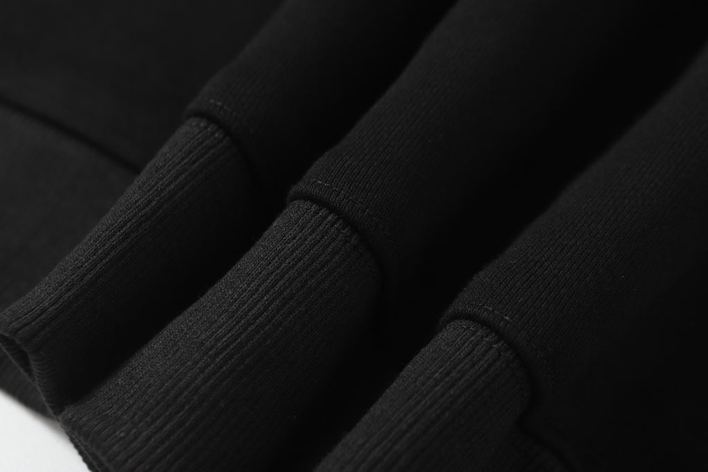 Black ribbed cuffs on sleeves of hooded zip jacket