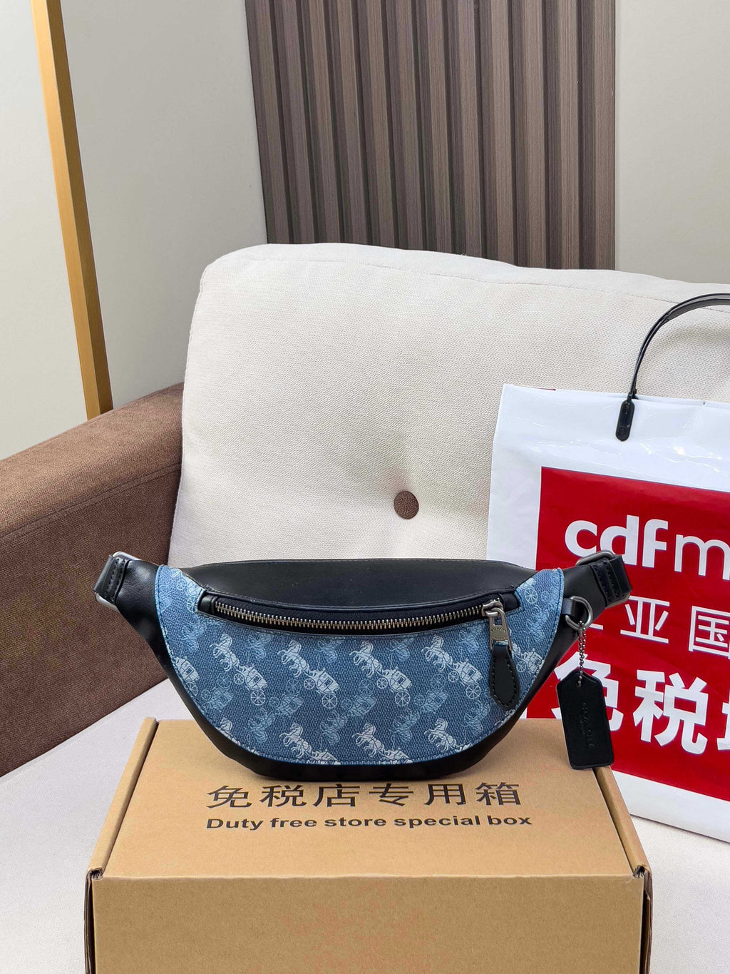 Coah belt bag, blue patterned body with black top handle and zip pocket