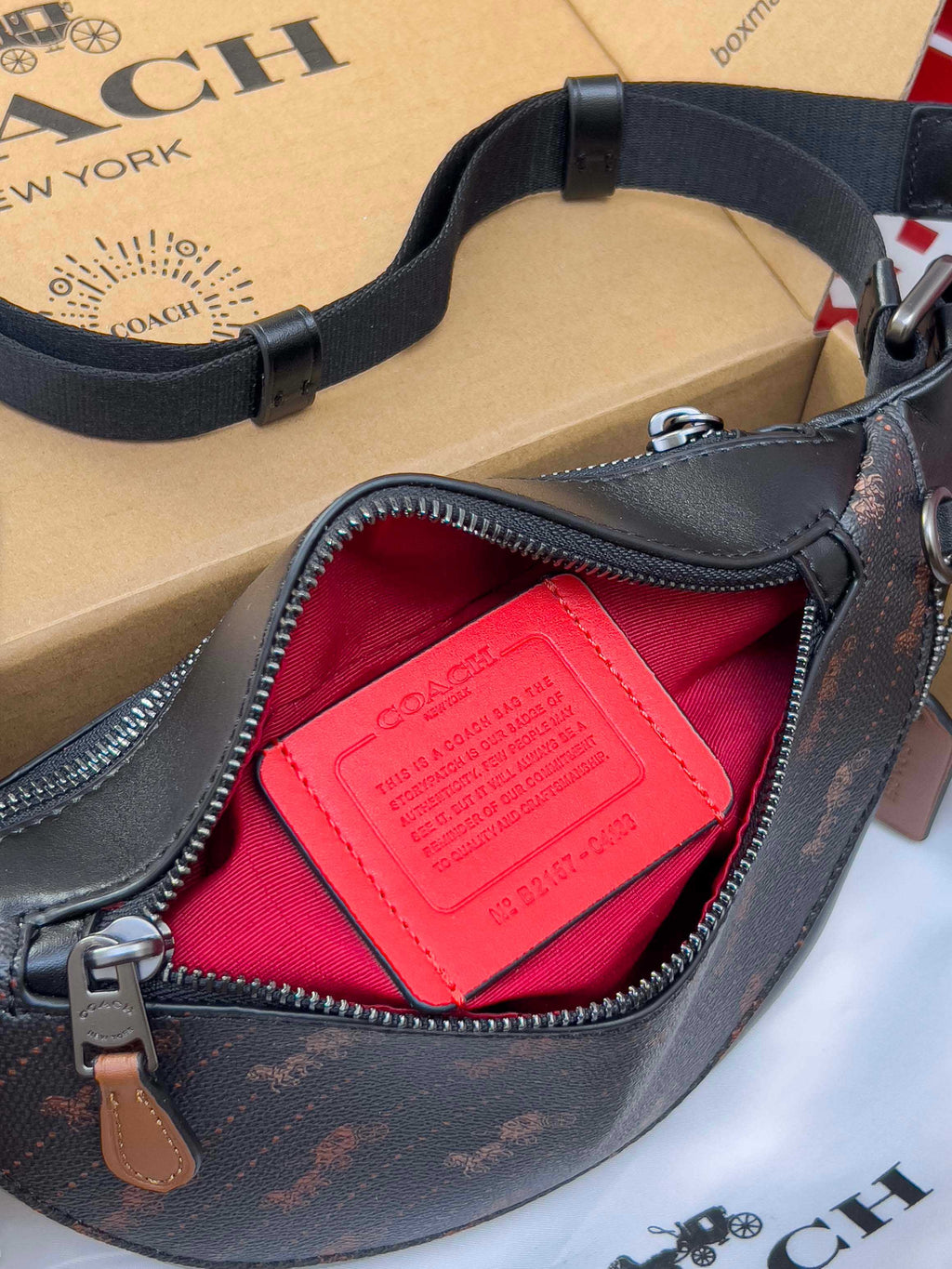 Coah crossbody bag, close-up of zip opening showing red lining and leather tag