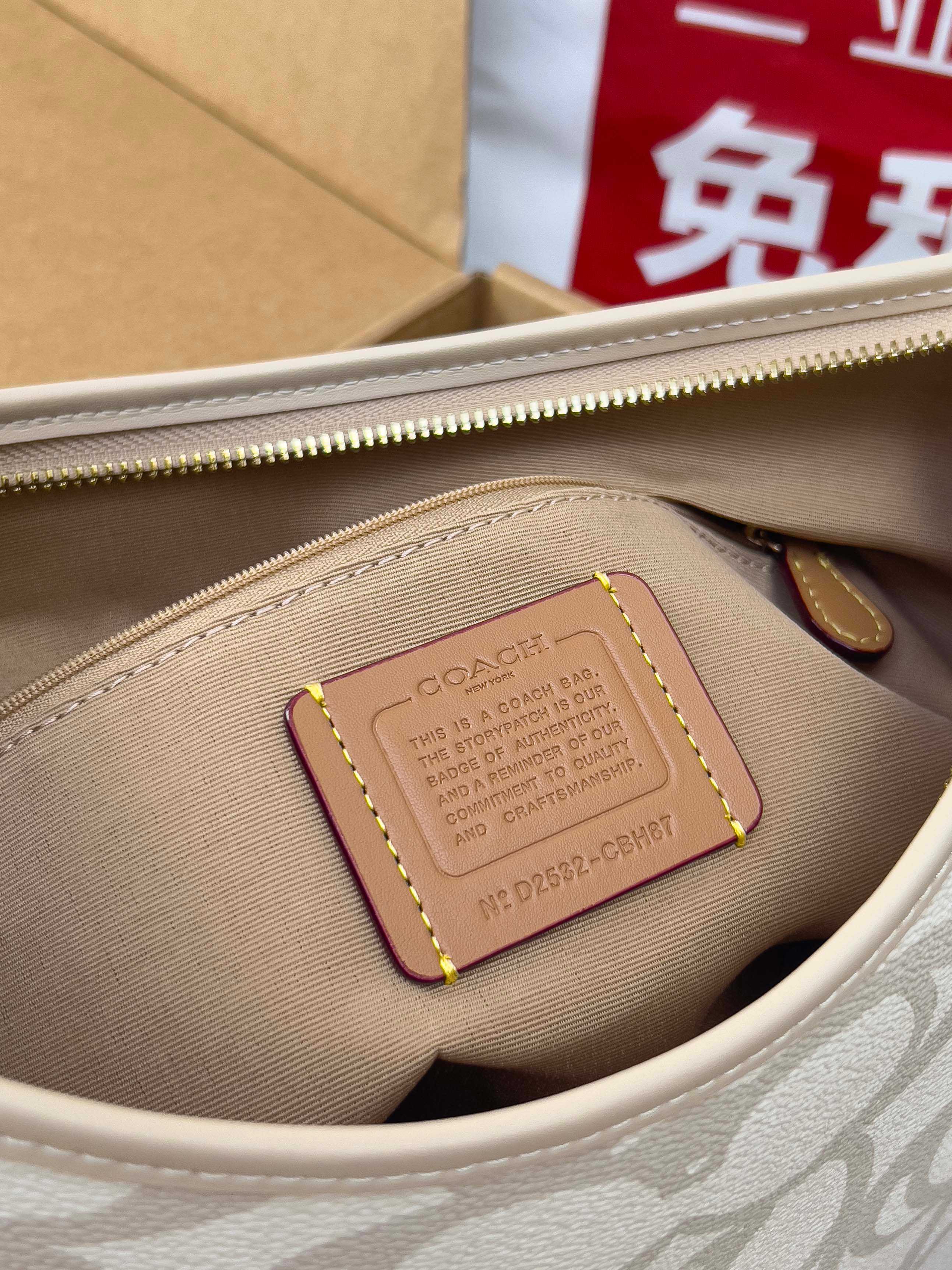 Coach bag interior with zipper, beige lining, and leather tag inside the pocket.