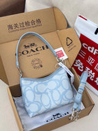 Light blue Coach small shoulder bag with patterned front and adjustable strap
