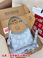 Light blue Coach small shoulder bag with patterned front and crossbody strap