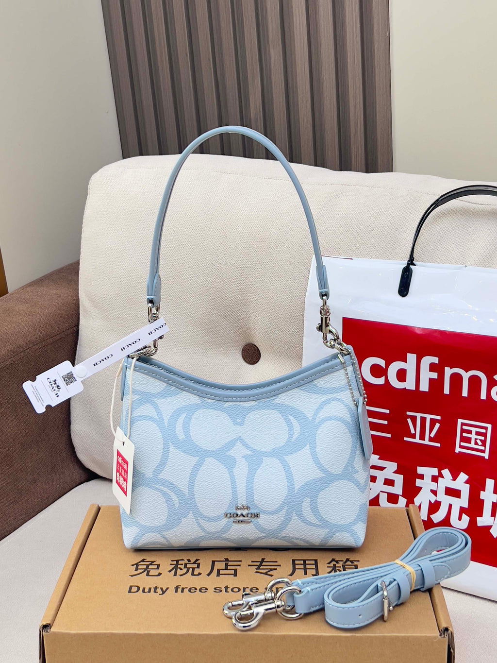 Light blue Coach mini shoulder bag with patterned body and detachable strap
