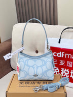 Light blue Coach mini shoulder bag with patterned body and detachable strap