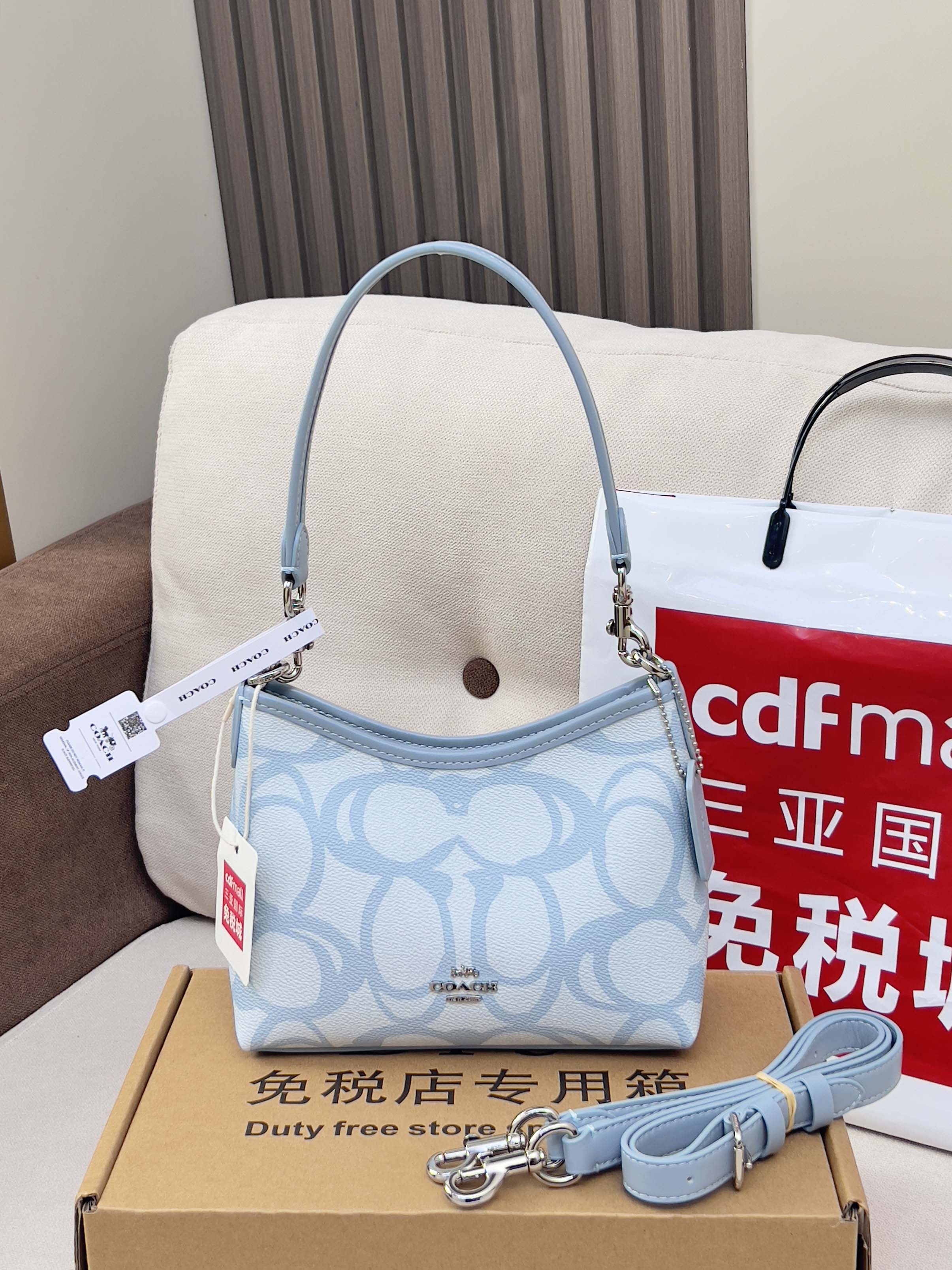 Light blue Coach mini shoulder bag with patterned body and detachable strap