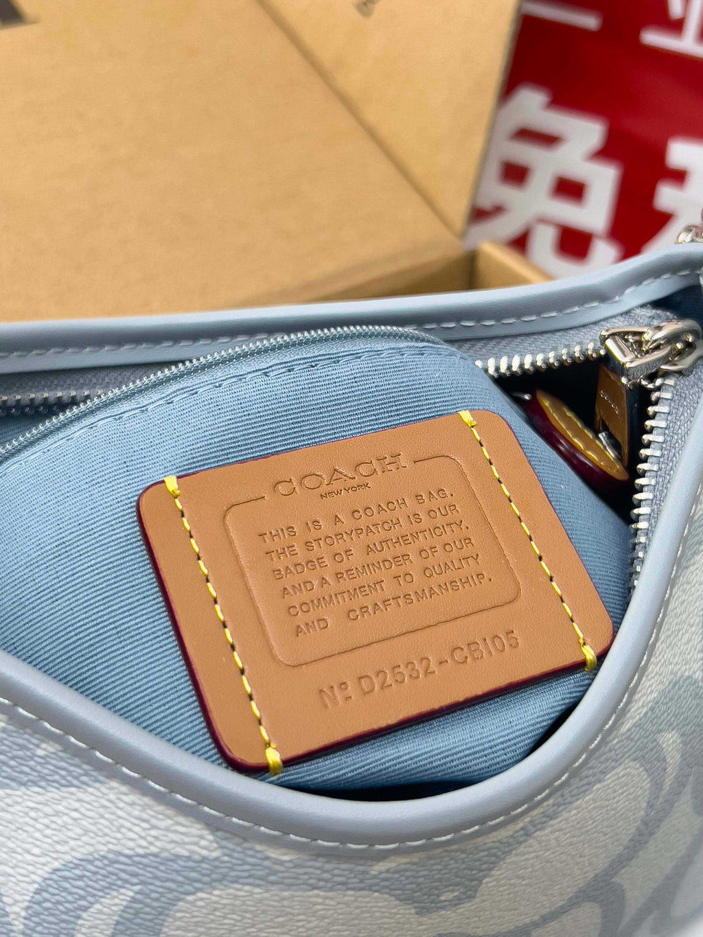 Light blue Coach bag interior leather patch near zipper with gold-tone hardware
