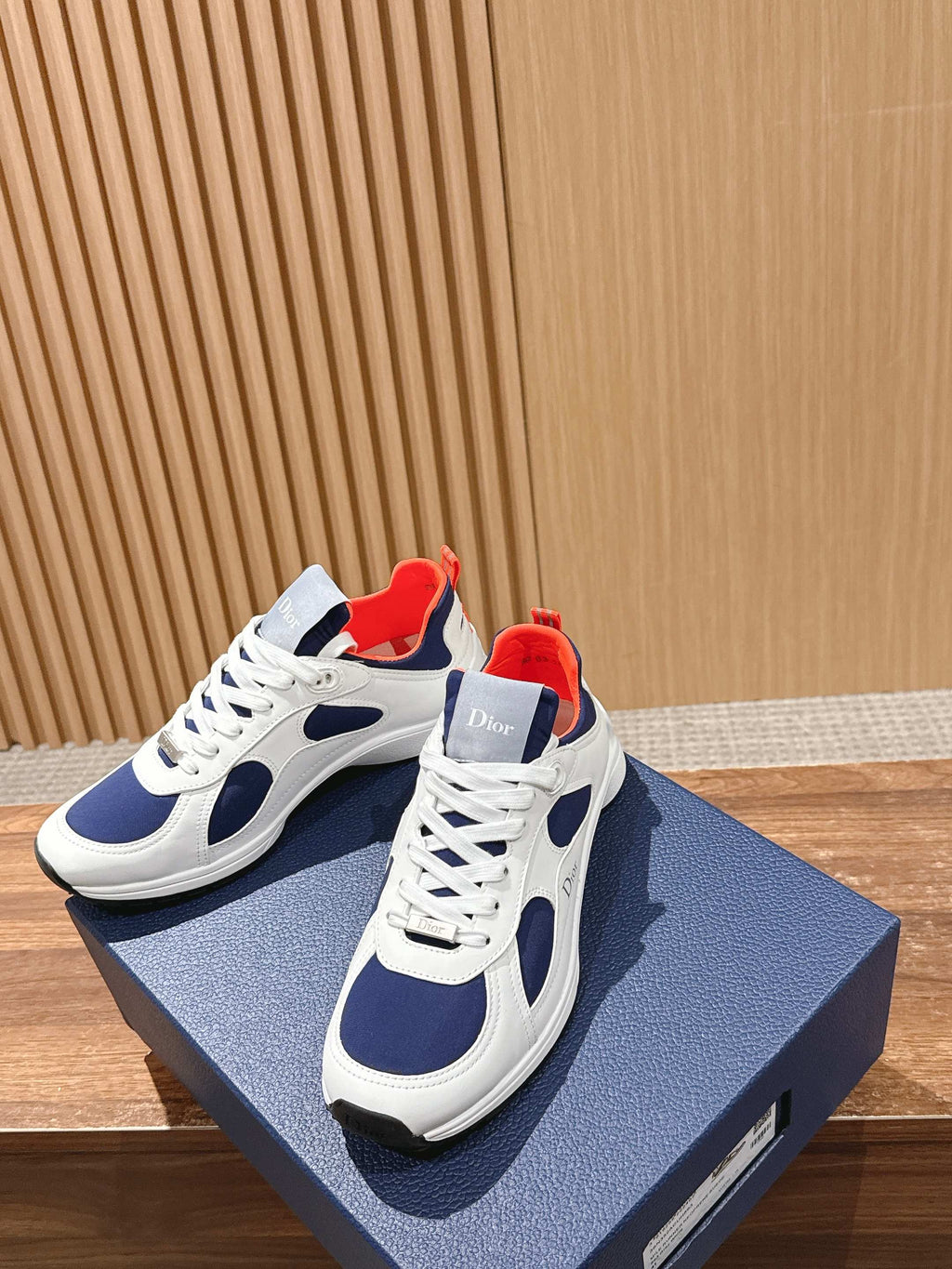 White and navy unisex low-top sneakers with red collar lining, lace-up style
