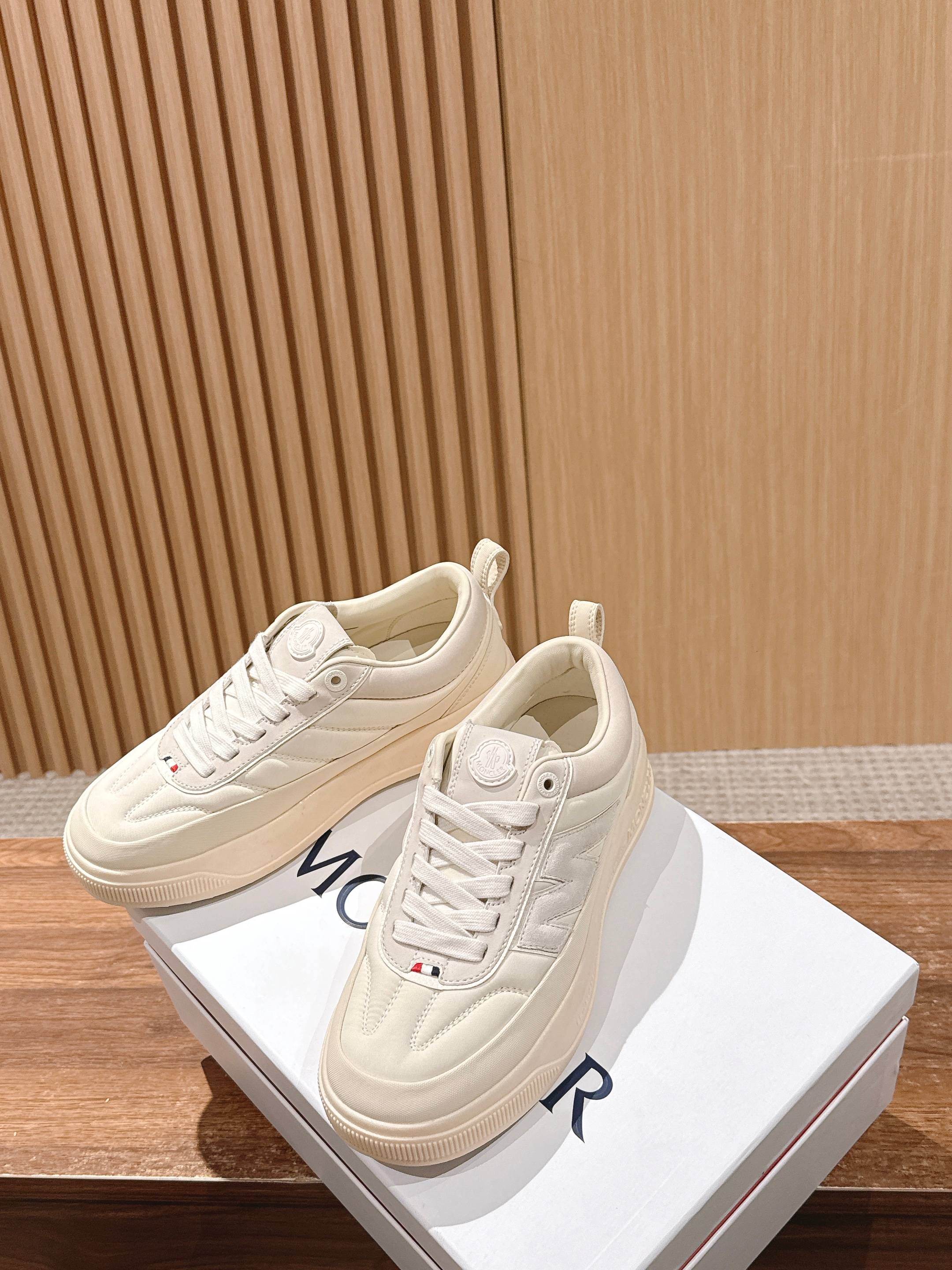 Moncler luxury shoes in cream, front and side pair on display with lace-up uppers.