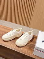 Moncler luxury shoes in cream, side view with lace-up front and stitched overlays.