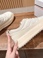 Moncler luxury shoes in cream, close-up side profile with chunky midsole and laces.