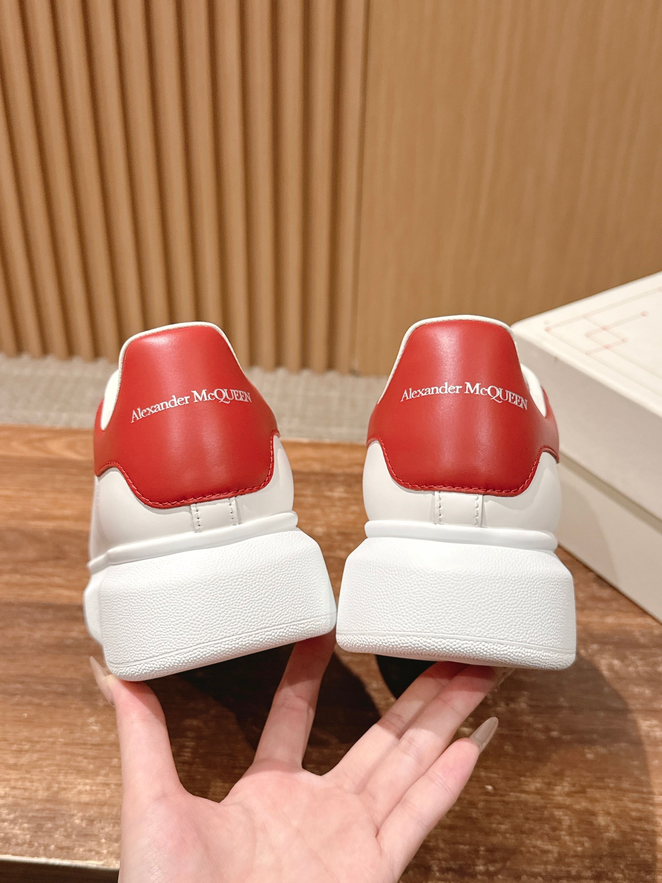 White sneakers with red back panels and thick white platform sole