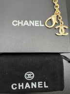 Chanel gold charm chain with fan detail and CC rings on black pouch