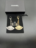 Chanel fan charm set with silver and gold chain links on black pouch