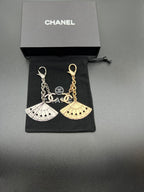 Chanel fan charm set with silver and gold chain links on black pouch