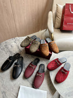 Assorted Gucci unisex slide mules: black, burgundy, olive-brown, and red GG canvas pairs.