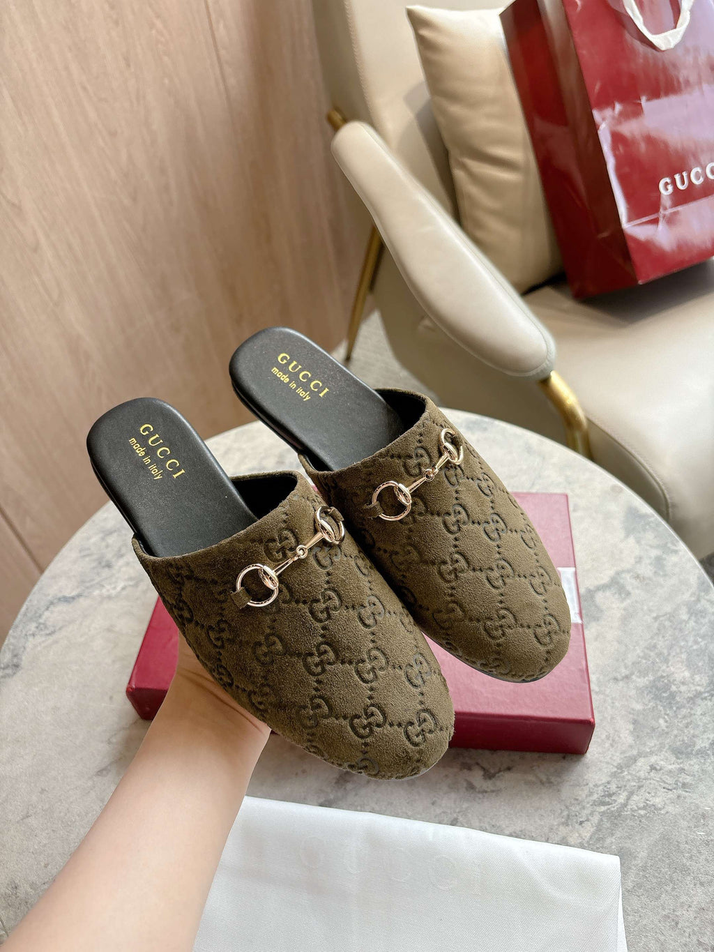 Gucci unisex slide mules with olive-brown GG canvas uppers and gold-tone horsebit detail.