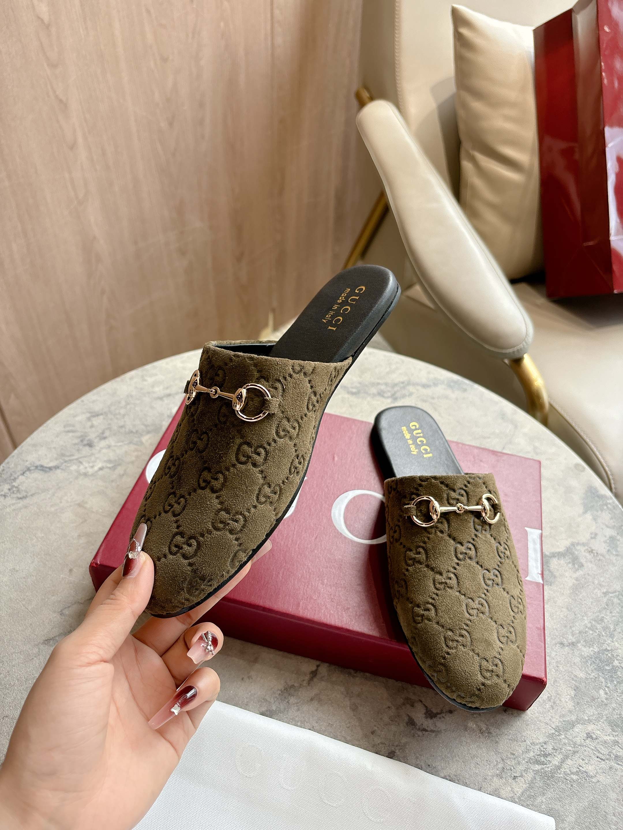 Gucci unisex slide mules in olive-brown GG canvas with gold-tone horsebit on the vamp.