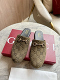 Gucci unisex slide mules in olive-brown GG canvas with gold-tone horsebit detail.