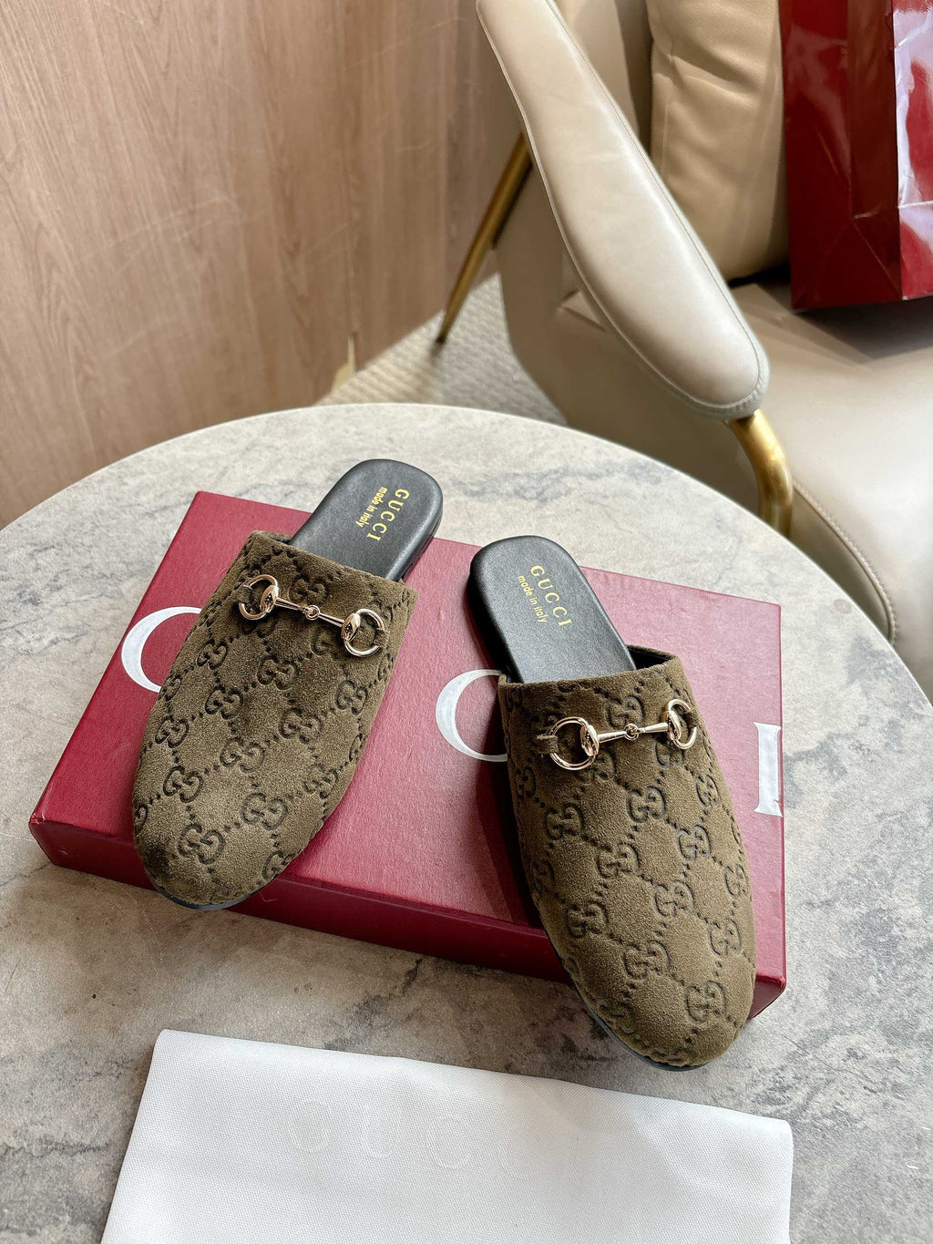 Gucci unisex slide mules, olive-brown GG canvas uppers with gold-tone horsebit hardware.
