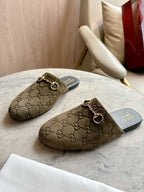 Pair of Gucci unisex slide mules in olive-brown GG canvas with gold-tone horsebit hardware.