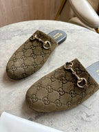 Close view of Gucci unisex slide mules in olive-brown GG canvas with gold-tone horsebit.