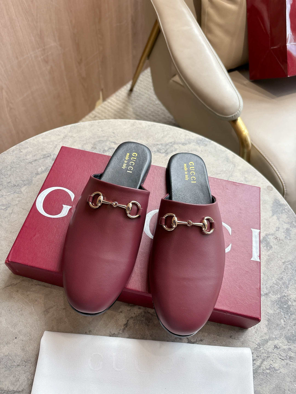 Burgundy leather mule loafers with gold-tone horsebit detail and black insoles