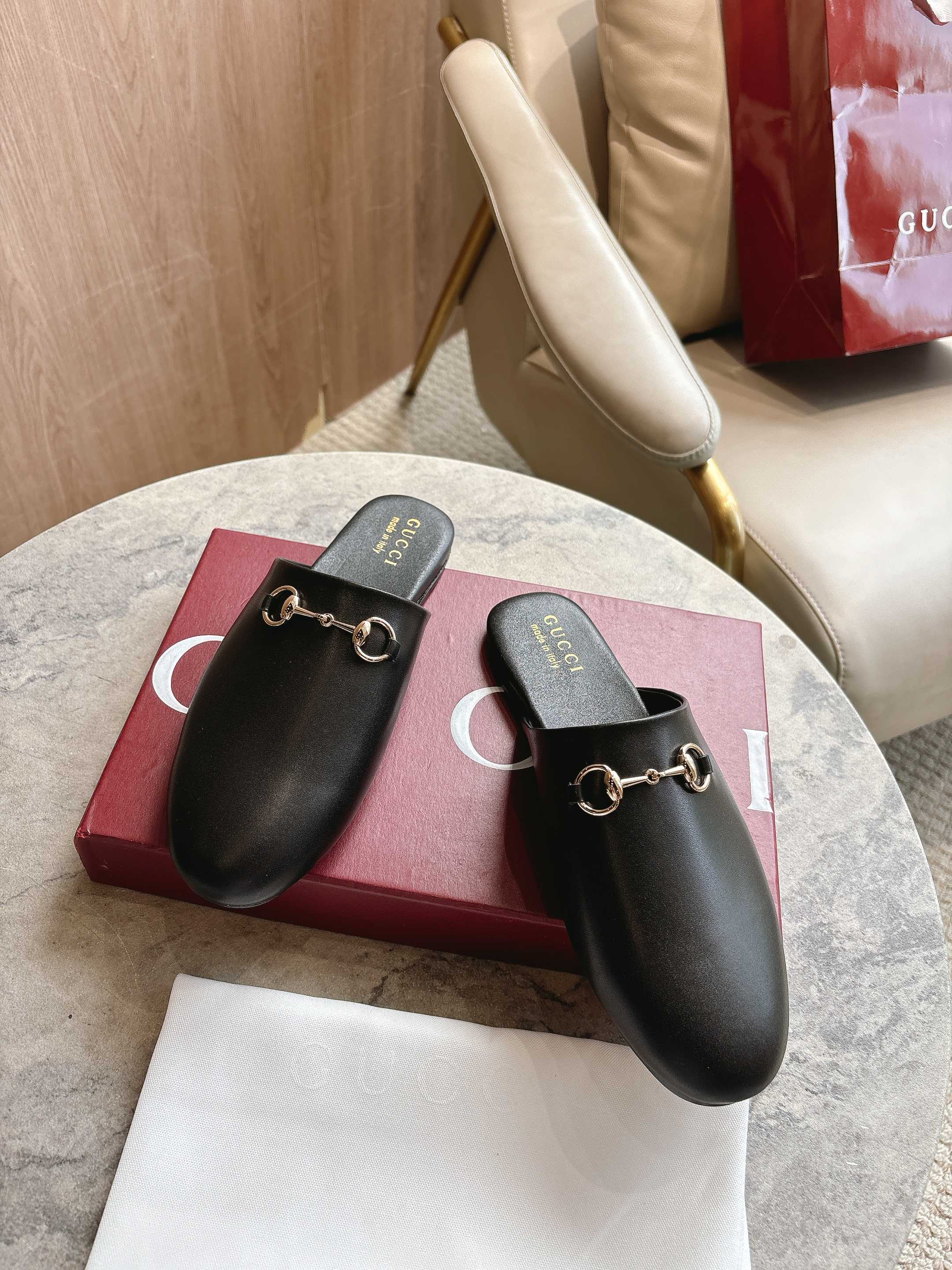 Black unisex loafers with gold chain buckle and cushioned footbed