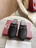 Black unisex loafers with gold chain detail and Gucci logo on footbed