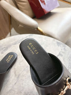 Black unisex slides with Gucci logo on dark footbed and stitched trim