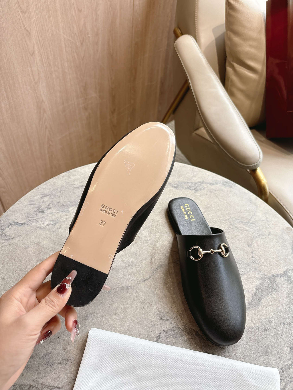 Black unisex loafer with gold chain detail and light beige sole underside